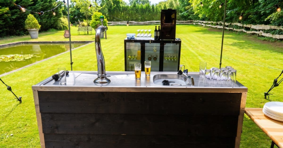 Mobiele buitenbar met luxe biertap en wijnkoelers in de tuin