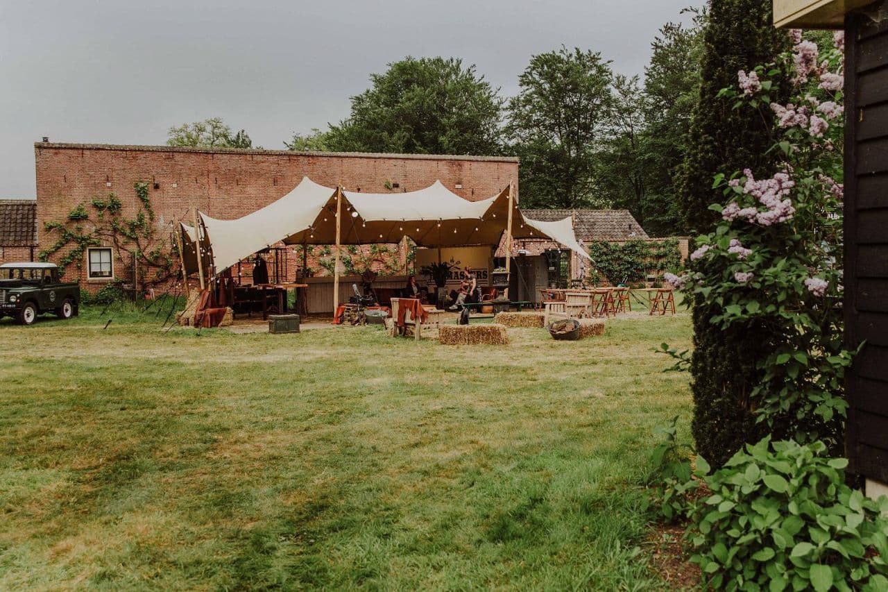 Stretchtent bij tuinborrel met strobalen